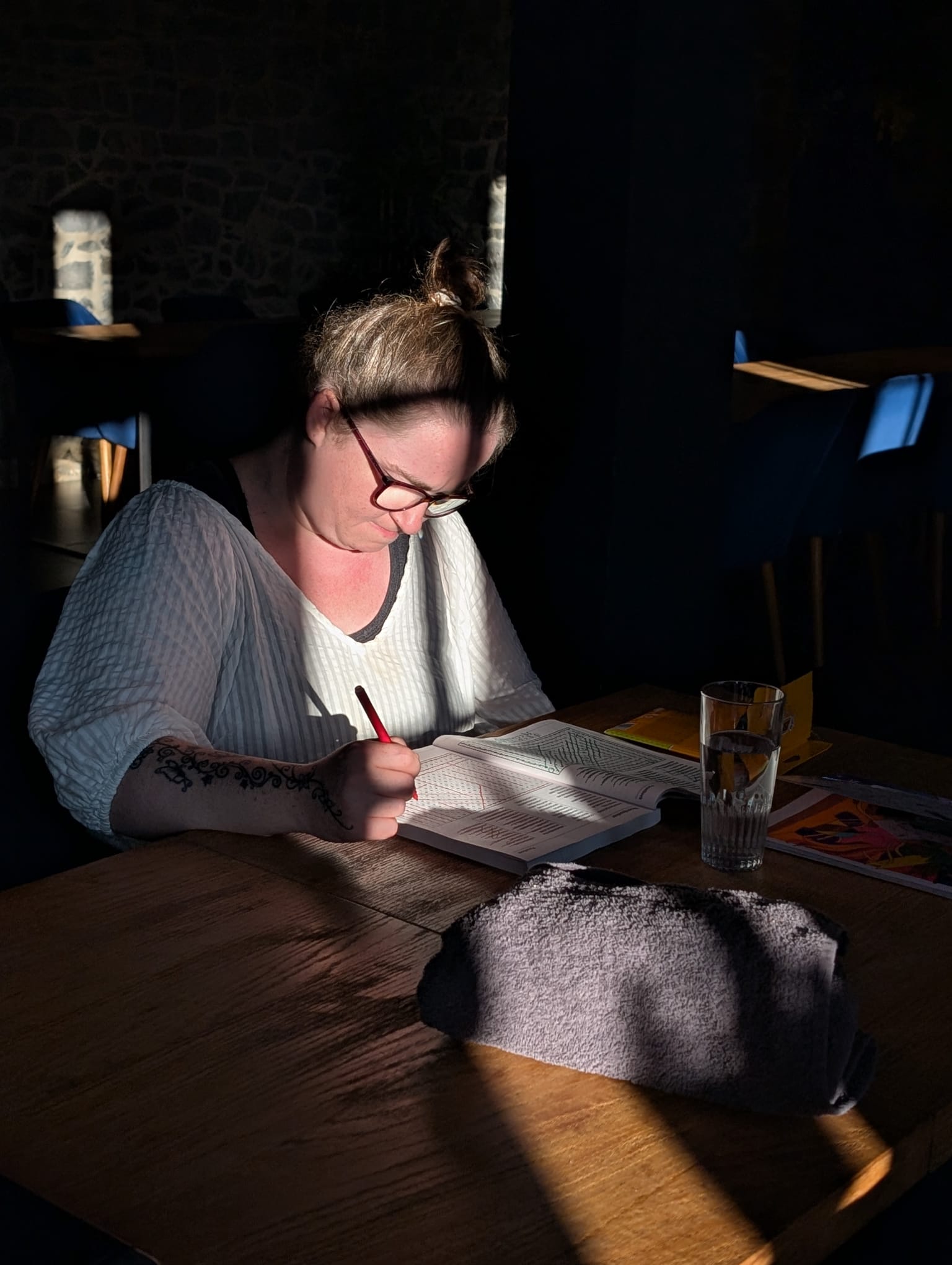 Een vrouw schrijft aan tafel in een boek